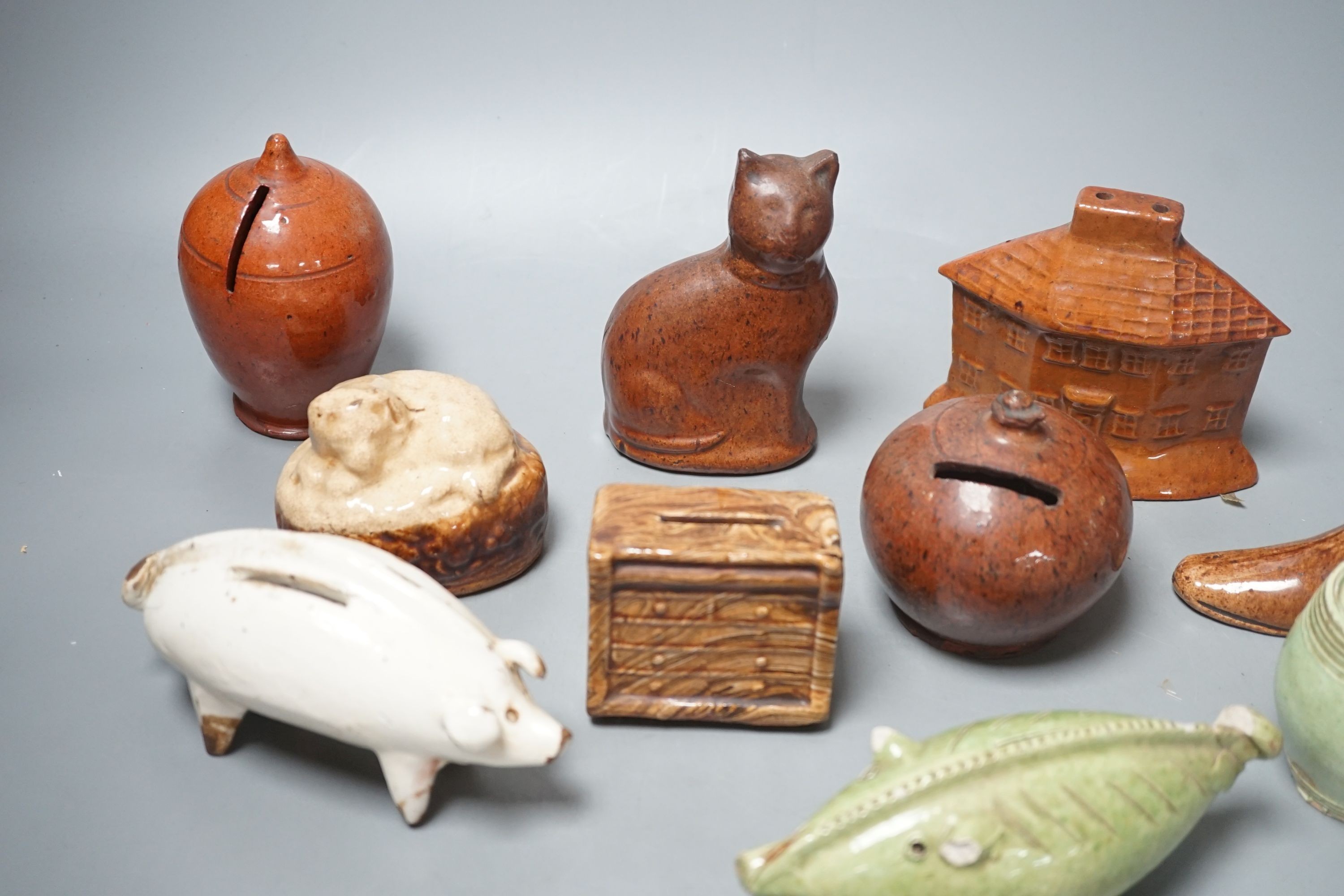 A collection of ten, 19th century Dutch and British pottery money boxes - tallest cat money box 12 cms high